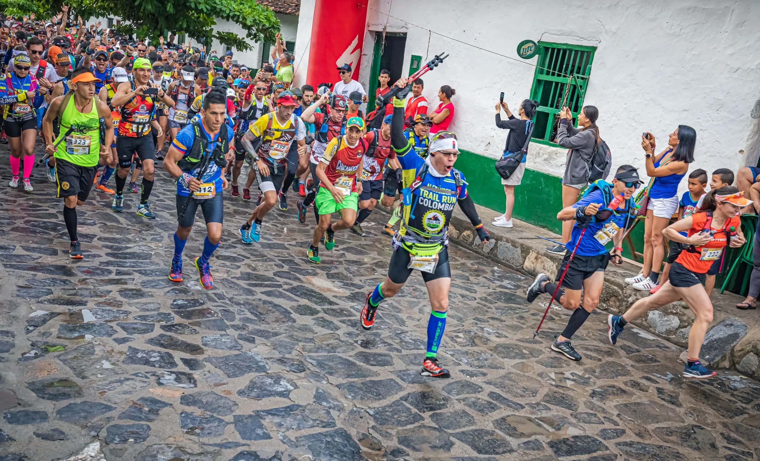 Dozens of runners setting off along a cobbled street lined with colonial houses