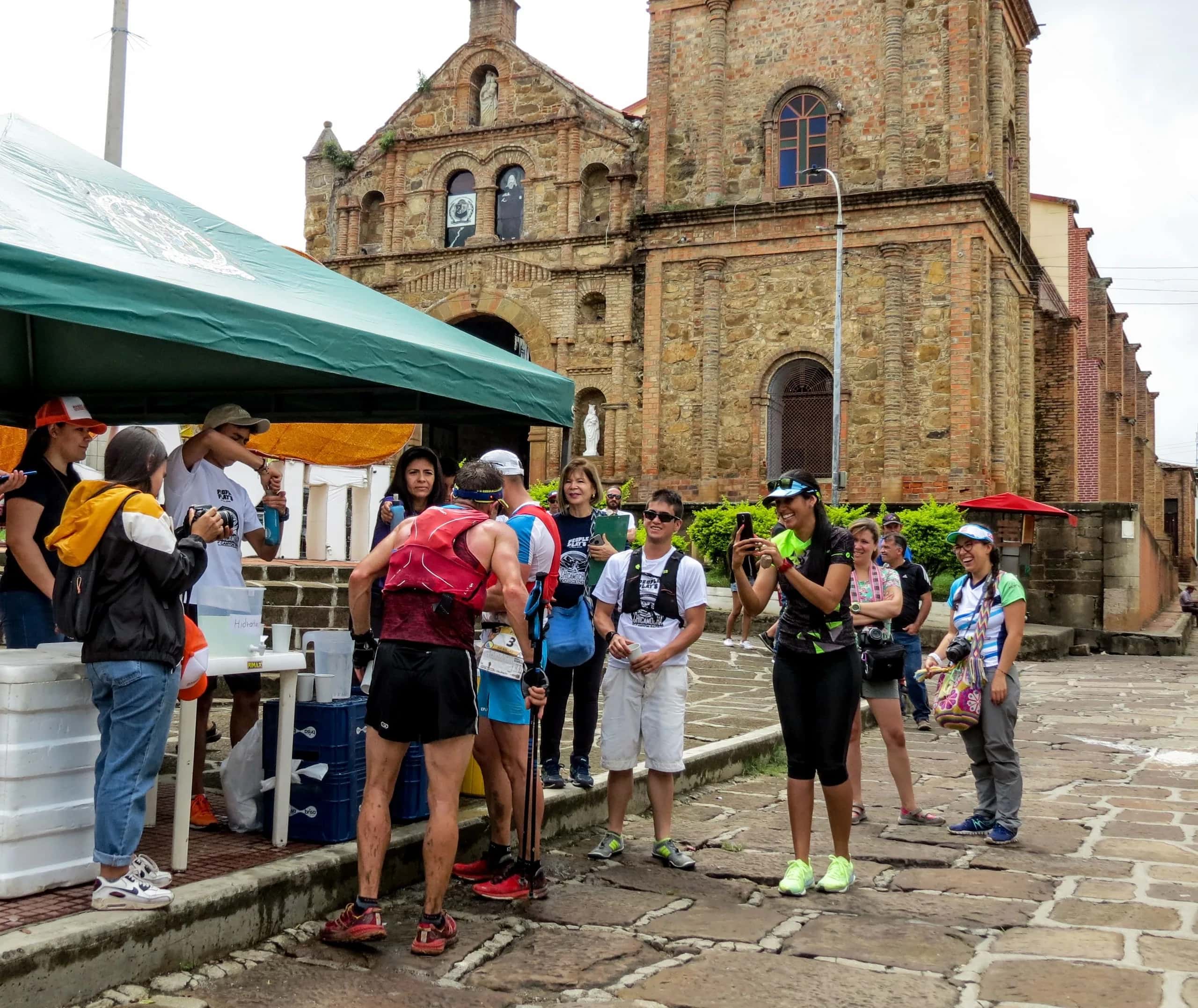 Aid station tent in front of a stone church, where volunteers look after the runners