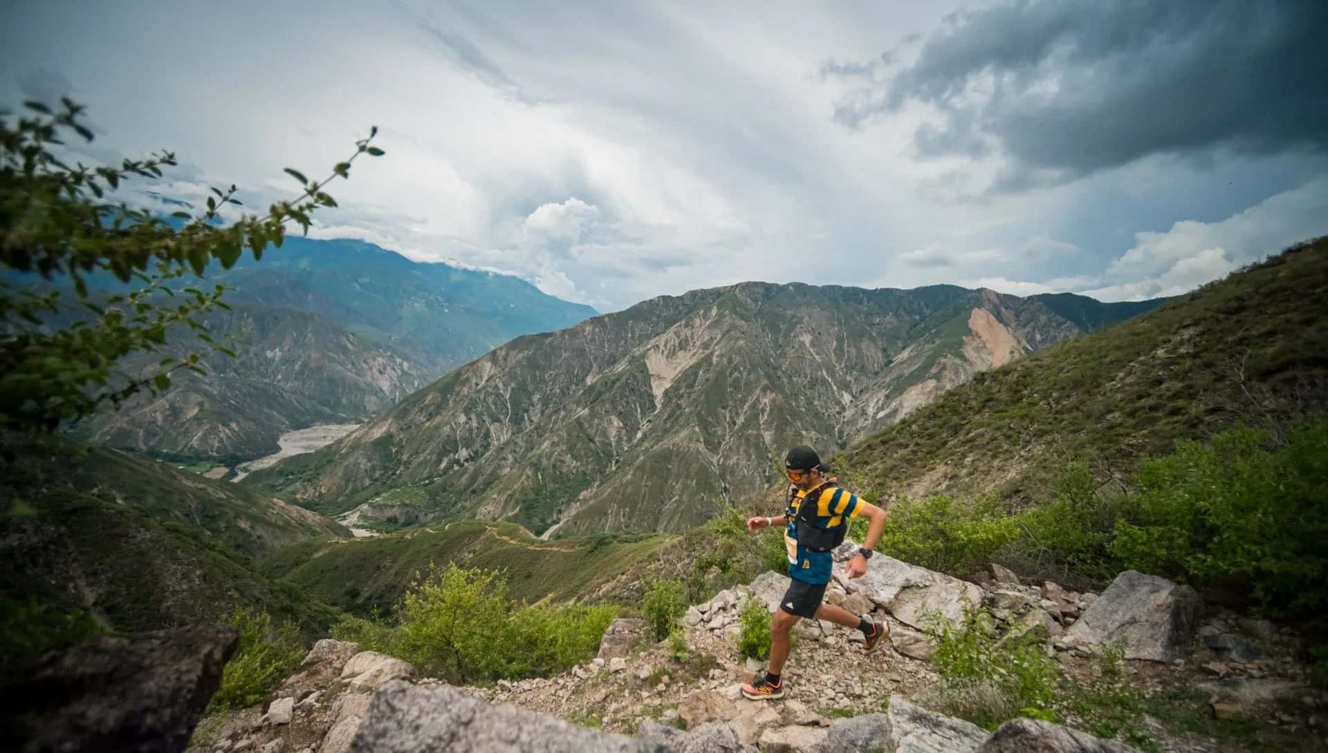 Runner on a rocky trail with the mountains of the Chicamocha Canyon behind