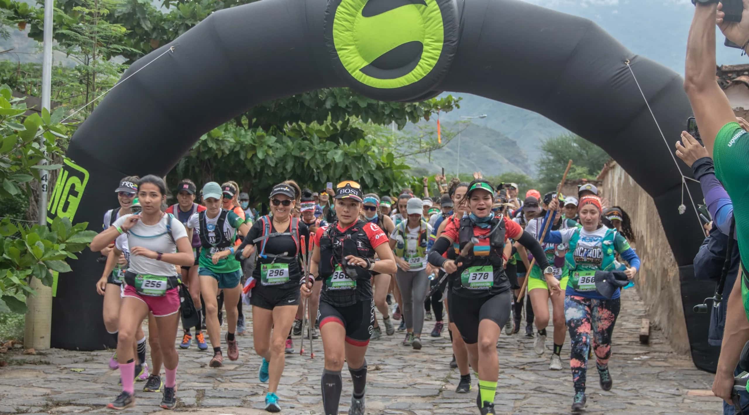Runners set off under an inflatable arch along a cobbled street at the start of the 2021 edition