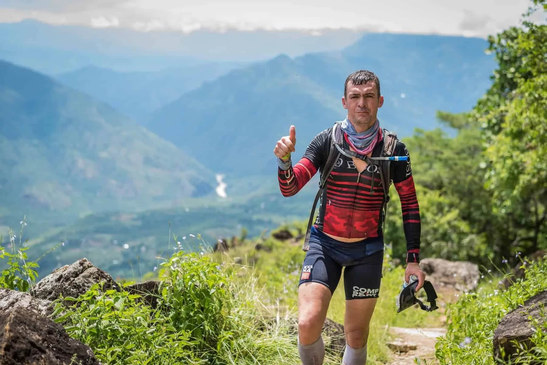 Runner giving a thumbs up on a trail overlooking the Chicamocha River
