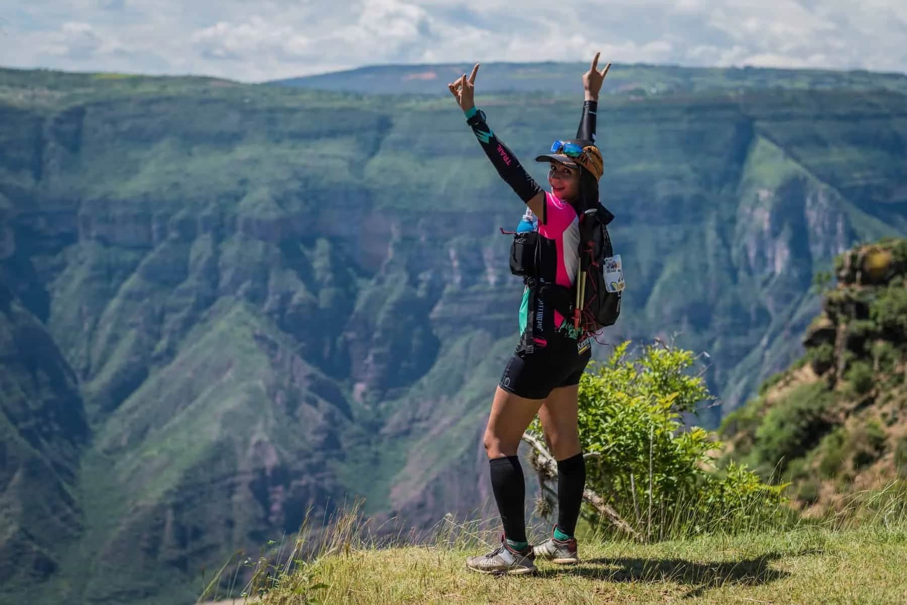 Runner celebrating with arms raised in front of the canyon walls