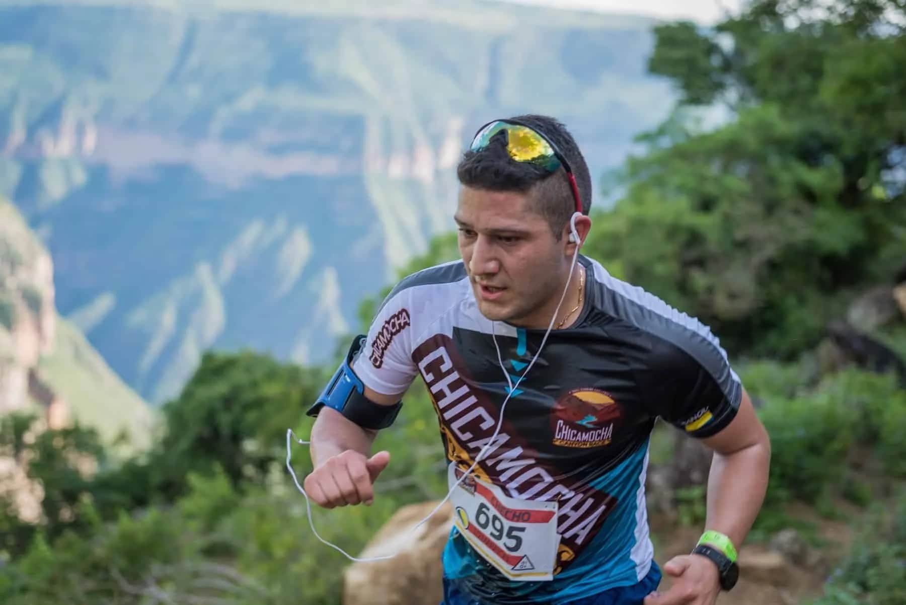 Focused runner in the race shirt with the canyon behind