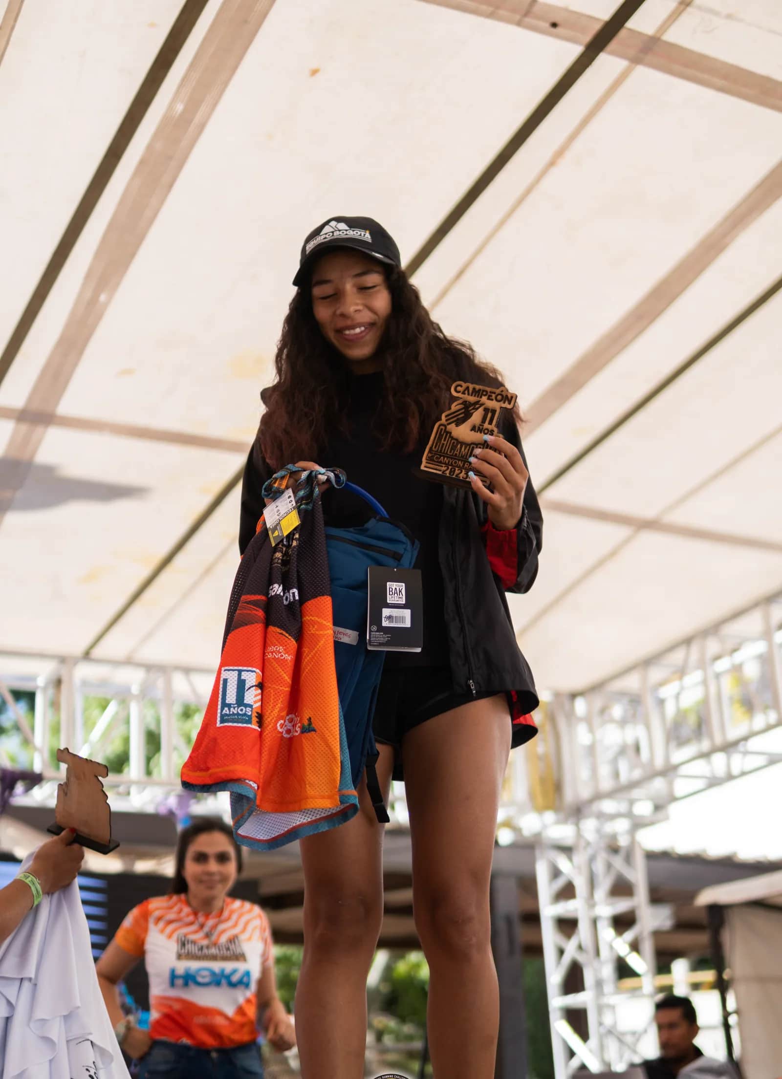 Runner smiling on the podium holding her prize