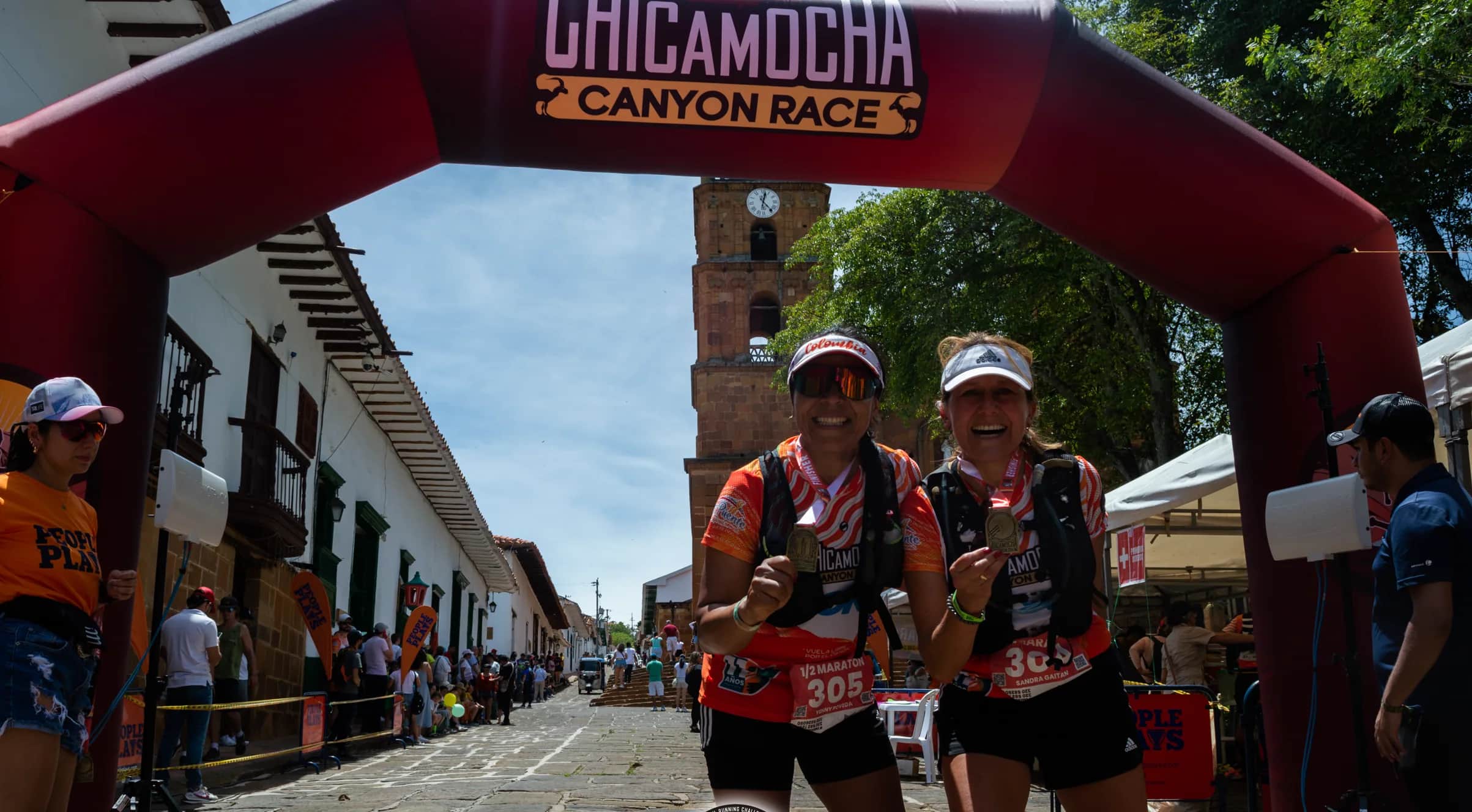 Two runners finishing together under the race arch
