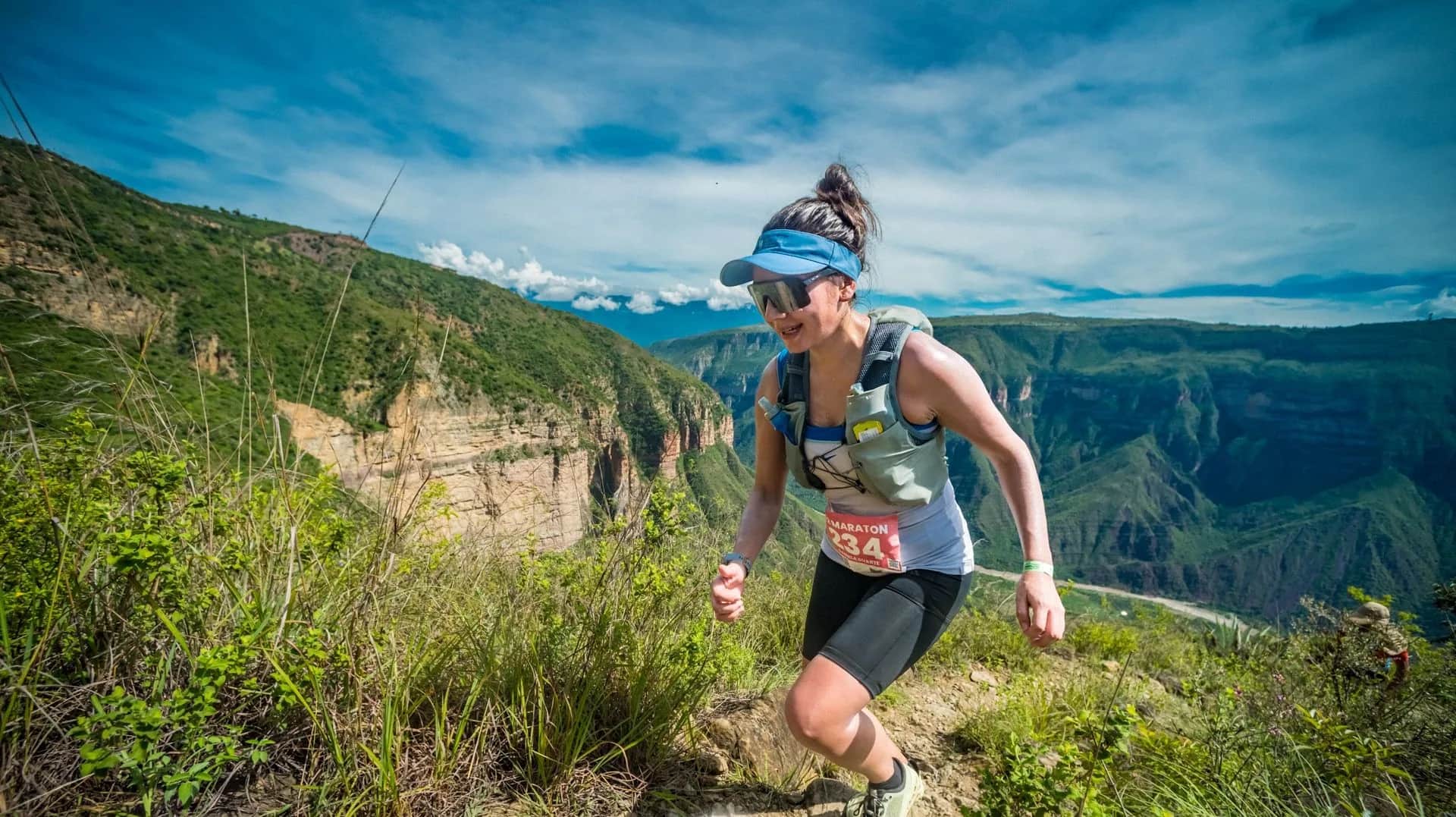 Smiling runner on the canyon rim under a blue sky