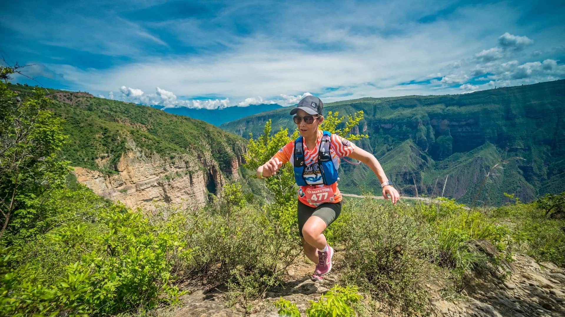Runner moving through scrub with the open canyon behind