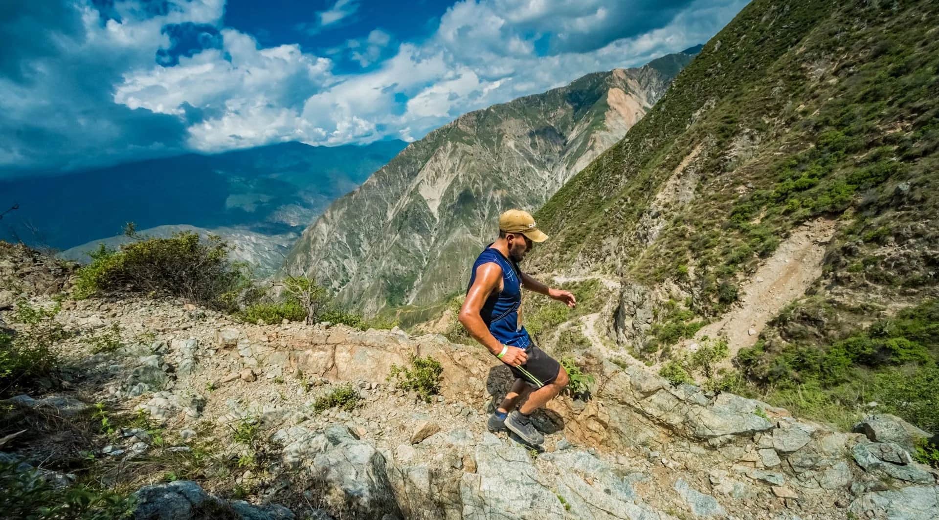 Runner on a technical trail of loose rock on the canyon slope