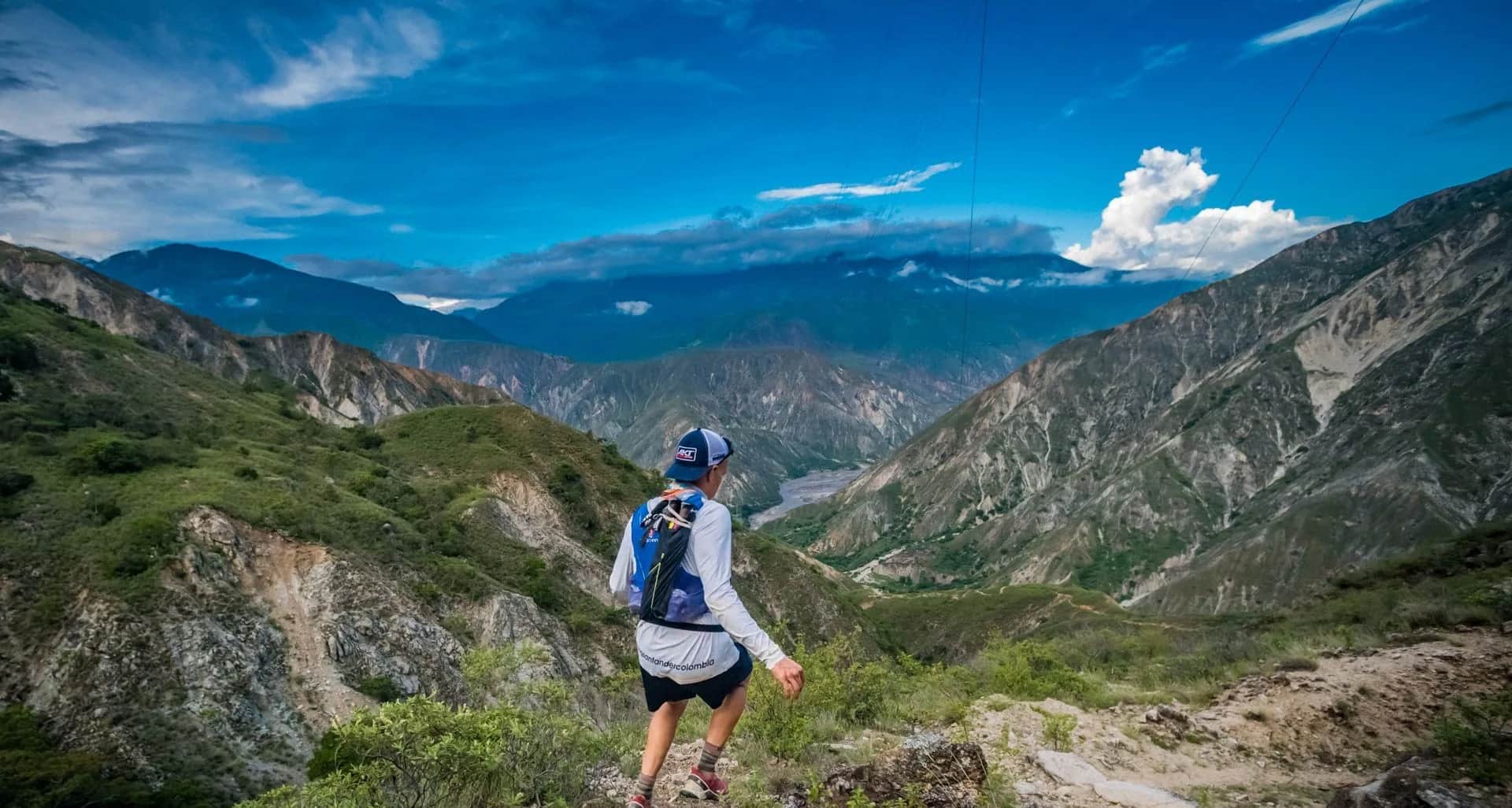 Runner heading down toward the canyon floor, with the river in the distance