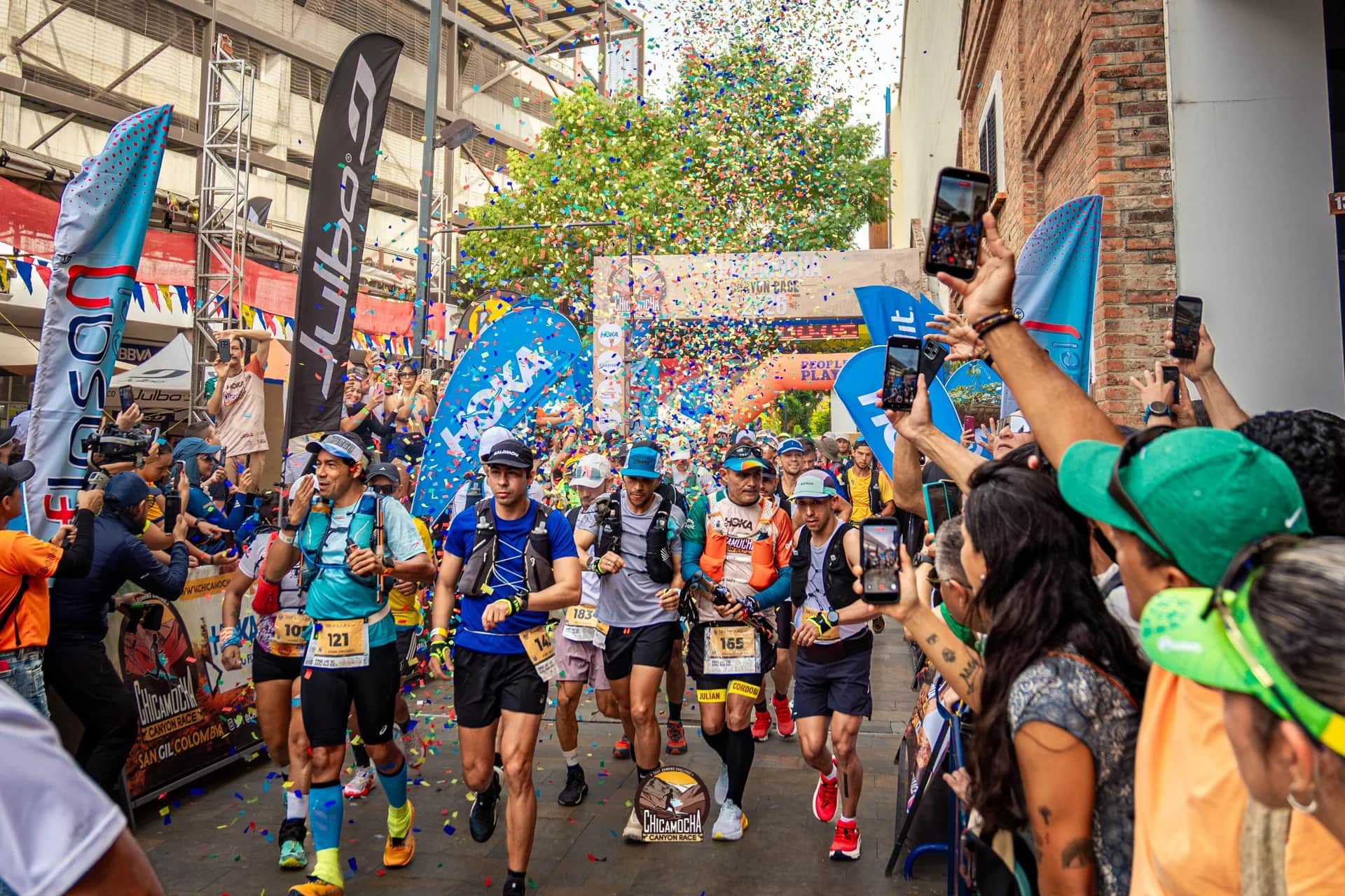 Start of the 2026 edition amid confetti: runners set off down a street packed with spectators filming on their phones