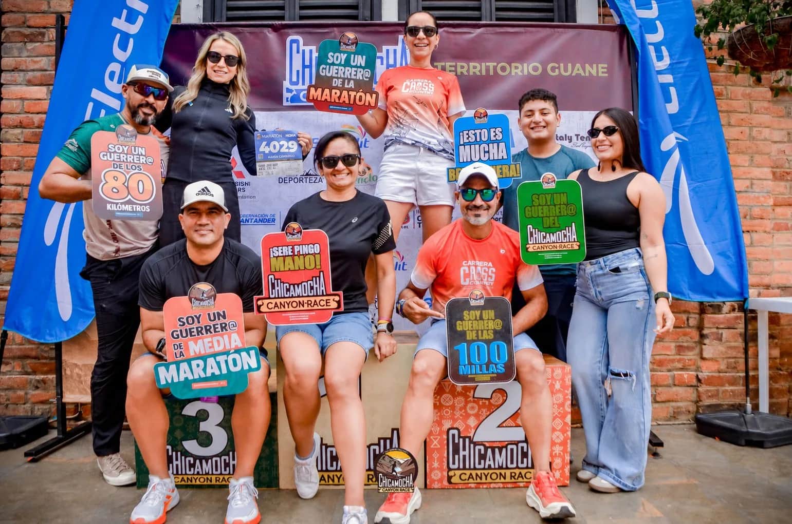 Runners pose with race signs at the photo spot during kit pickup