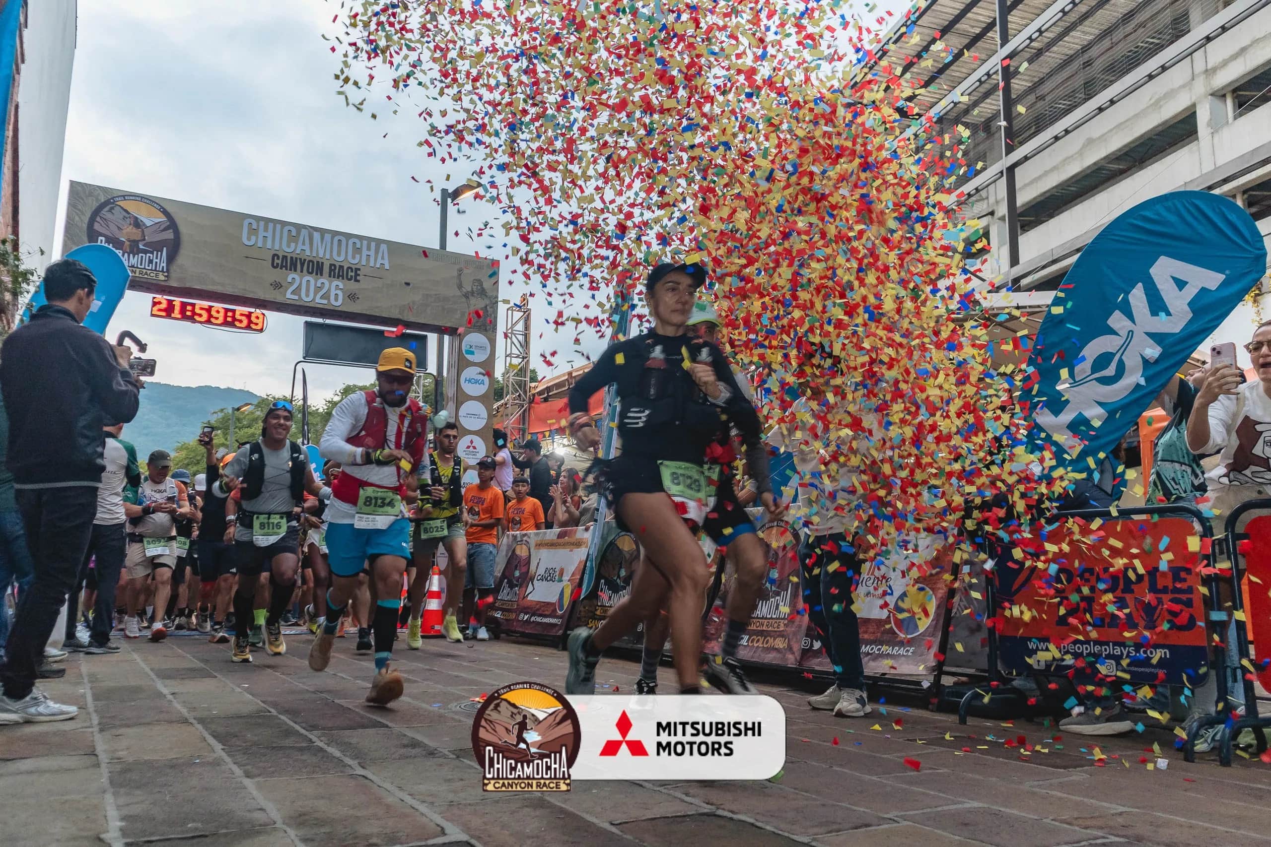 Runner crosses the 2026 finish line amid confetti, with the official clock behind