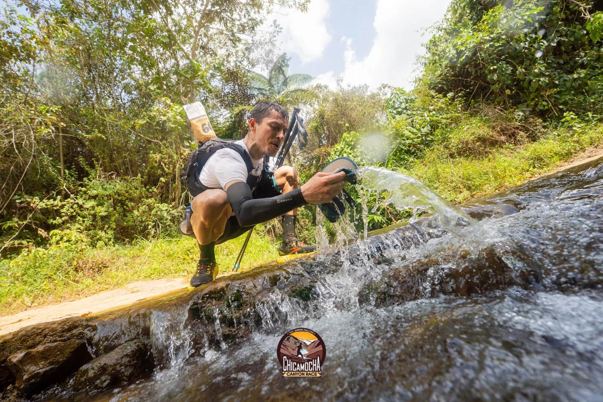 Corredor se refresca bajo una cascada junto al sendero