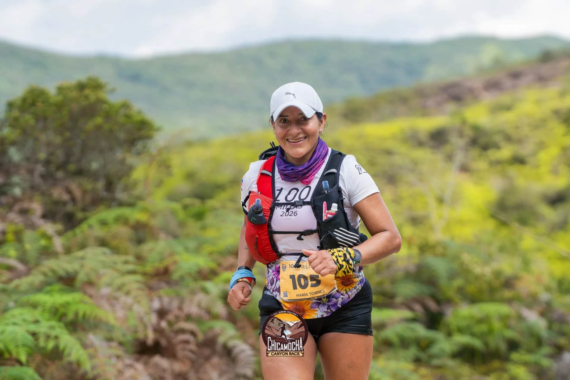Corredora de las 100 millas sonríe en un sendero entre helechos