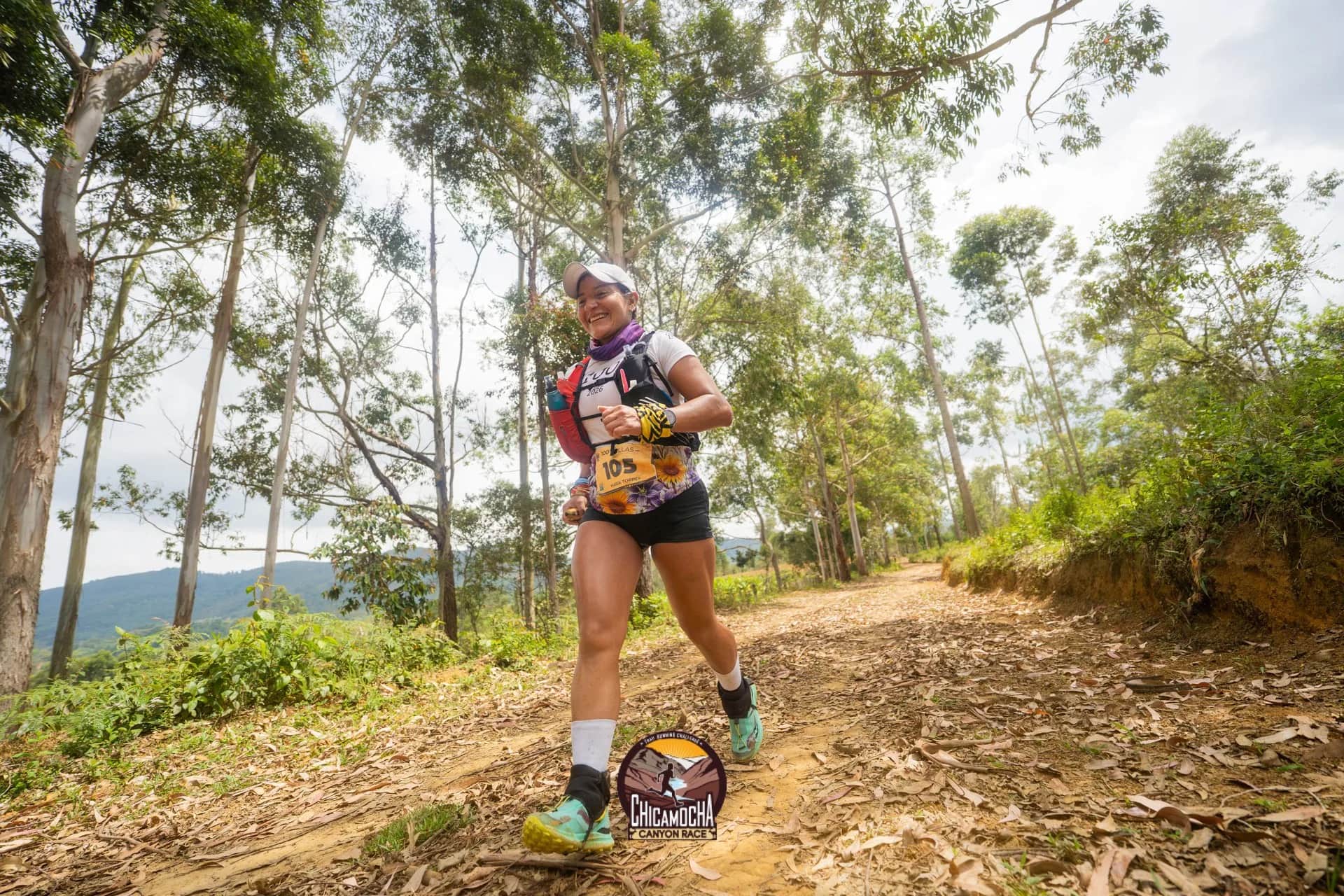 Runner with her bib on a path among eucalyptus trees