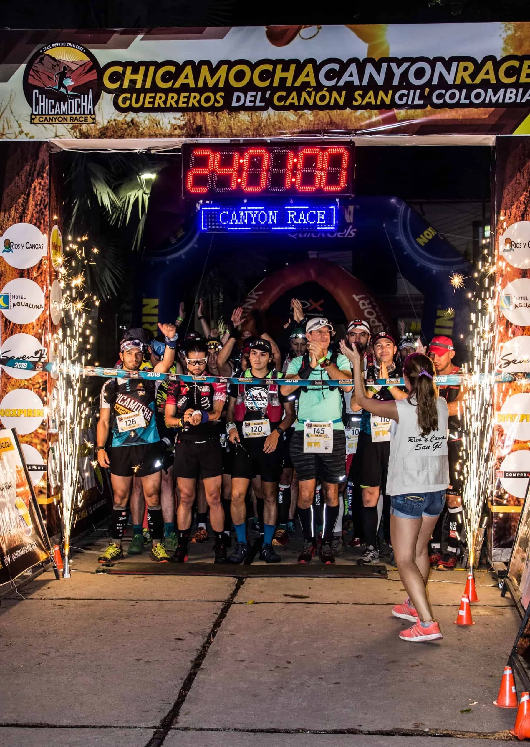 Night start under the race arch, with the clock running and sparklers on both sides