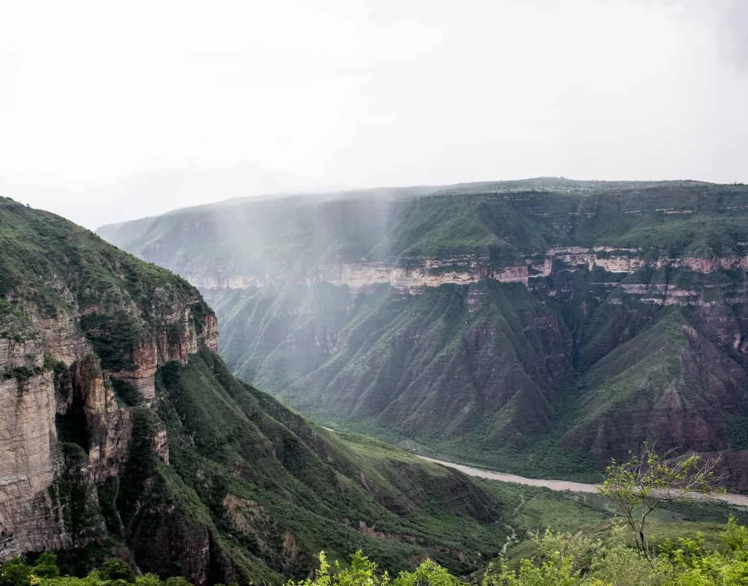 Chicamocha Canyon walls wrapped in rain and mist above the river