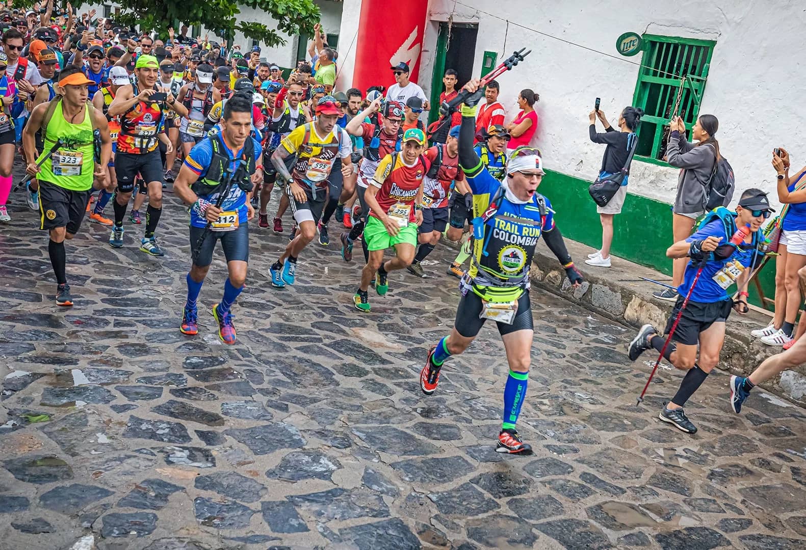 Pack of runners heading down a cobbled street in a Santander town