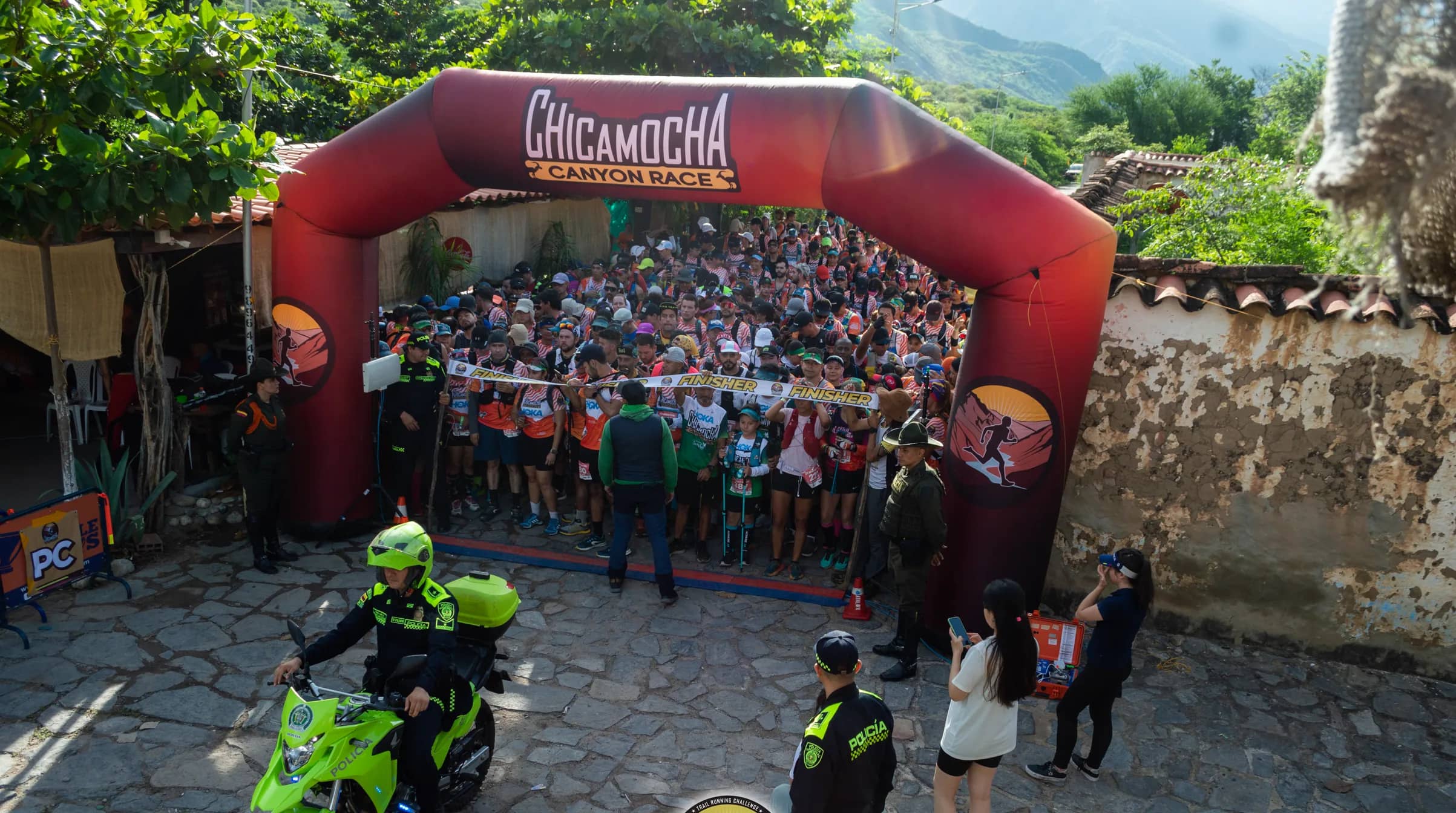 Mass start under the race arch, with a police officer on a motorbike leading the way