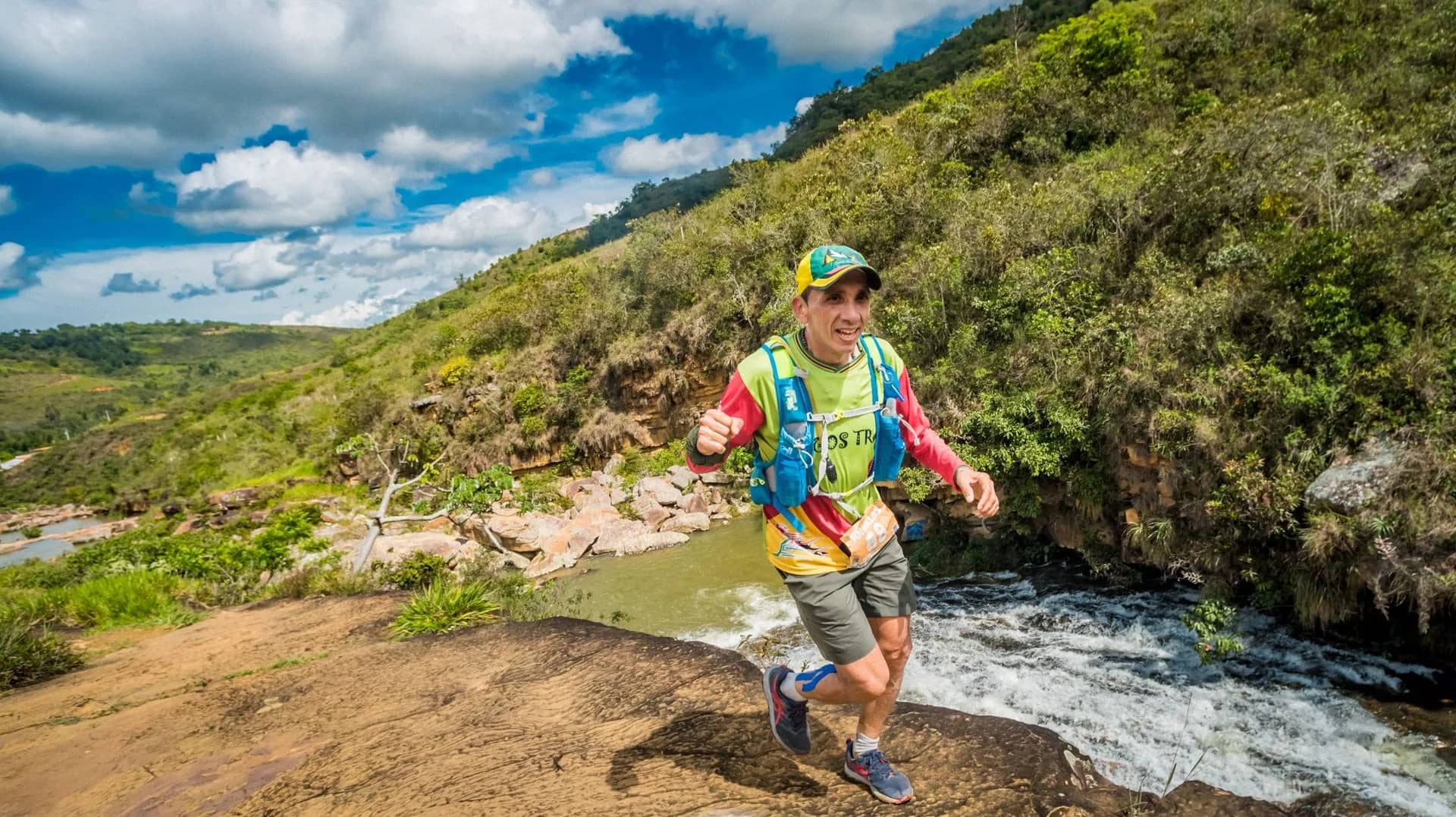 Runner moving across the rocks beside a fast-flowing river