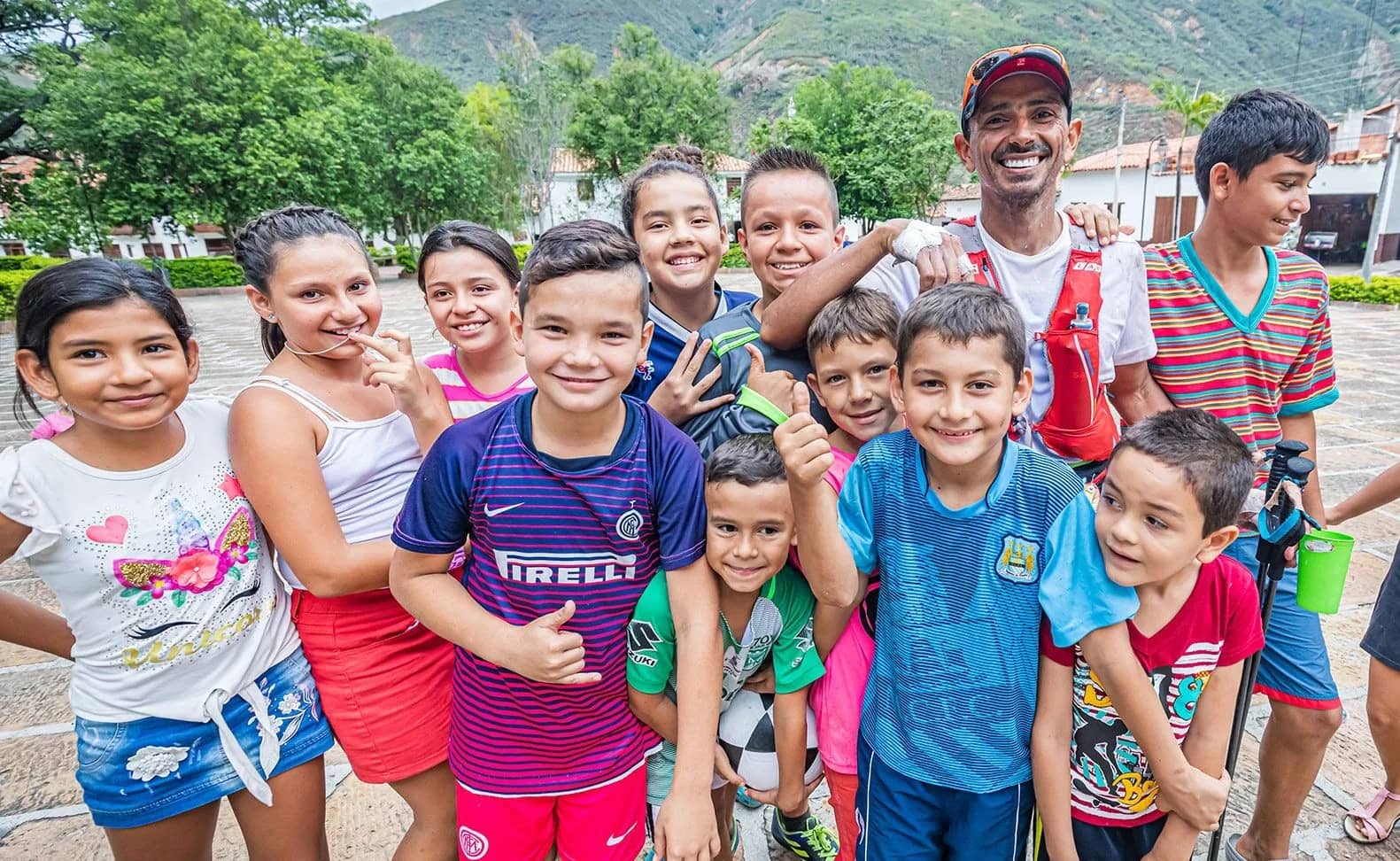 Children from a Santander town smiling next to a runner in the town square