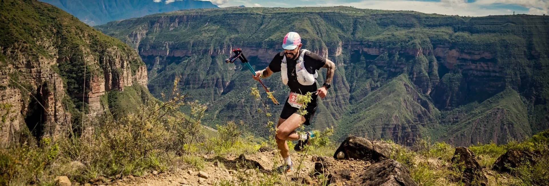 Runner with poles on a rocky trail above the Chicamocha Canyon