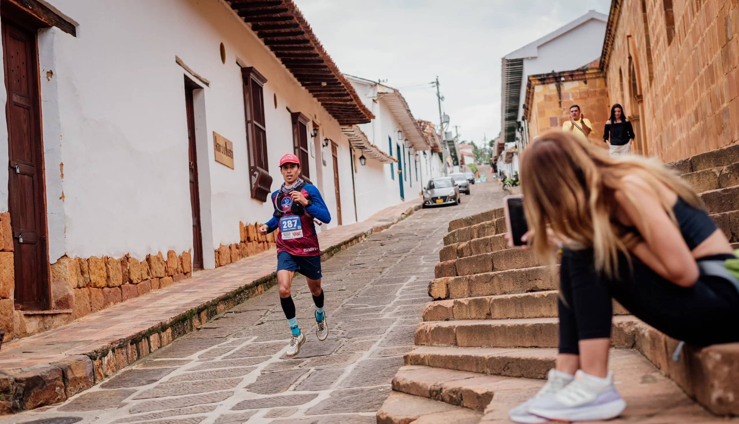 Runner coming down a cobbled colonial street beside stone steps