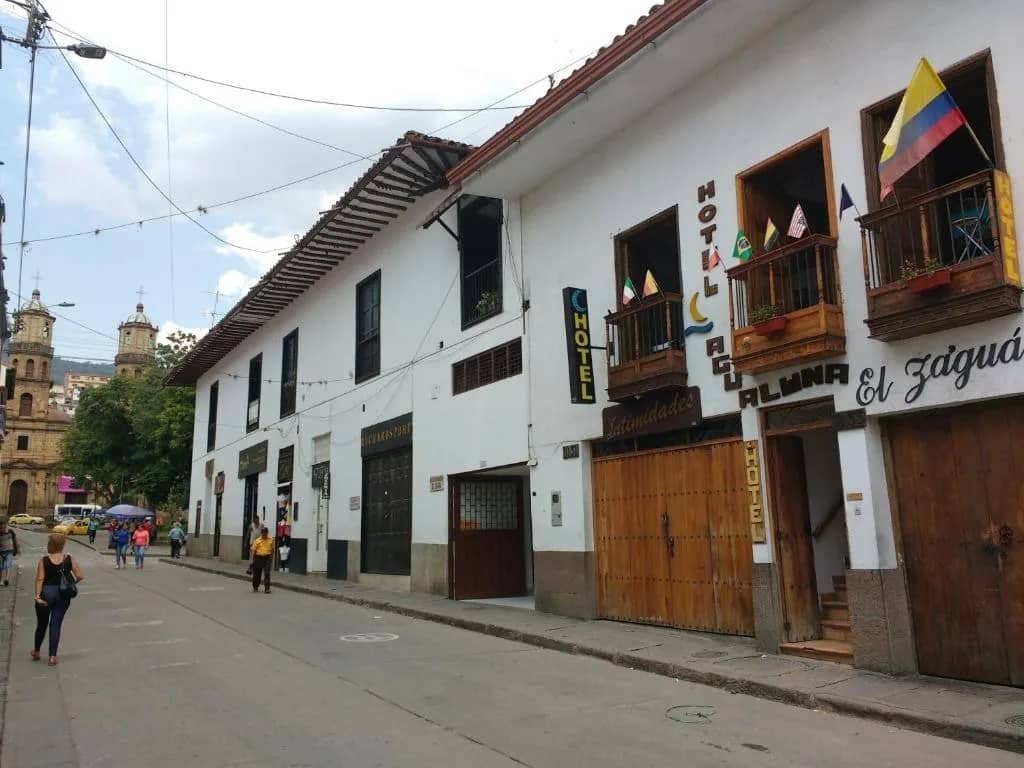 White colonial facade with wooden balconies of Hotel Agualuna on a downtown San Gil street