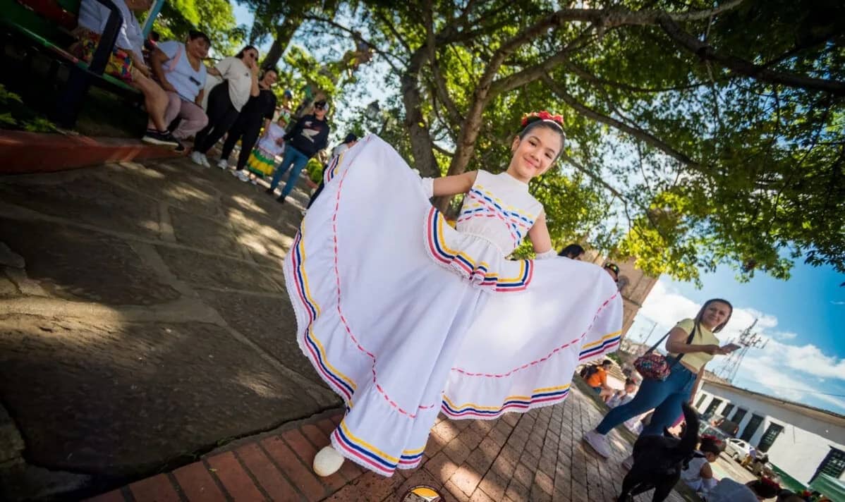 Girl in a traditional white dress dancing in a town square