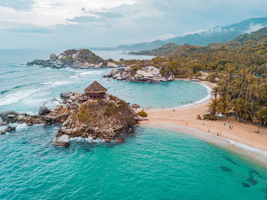 Turquoise bay with palm trees and boulders on the Colombian Caribbean coast