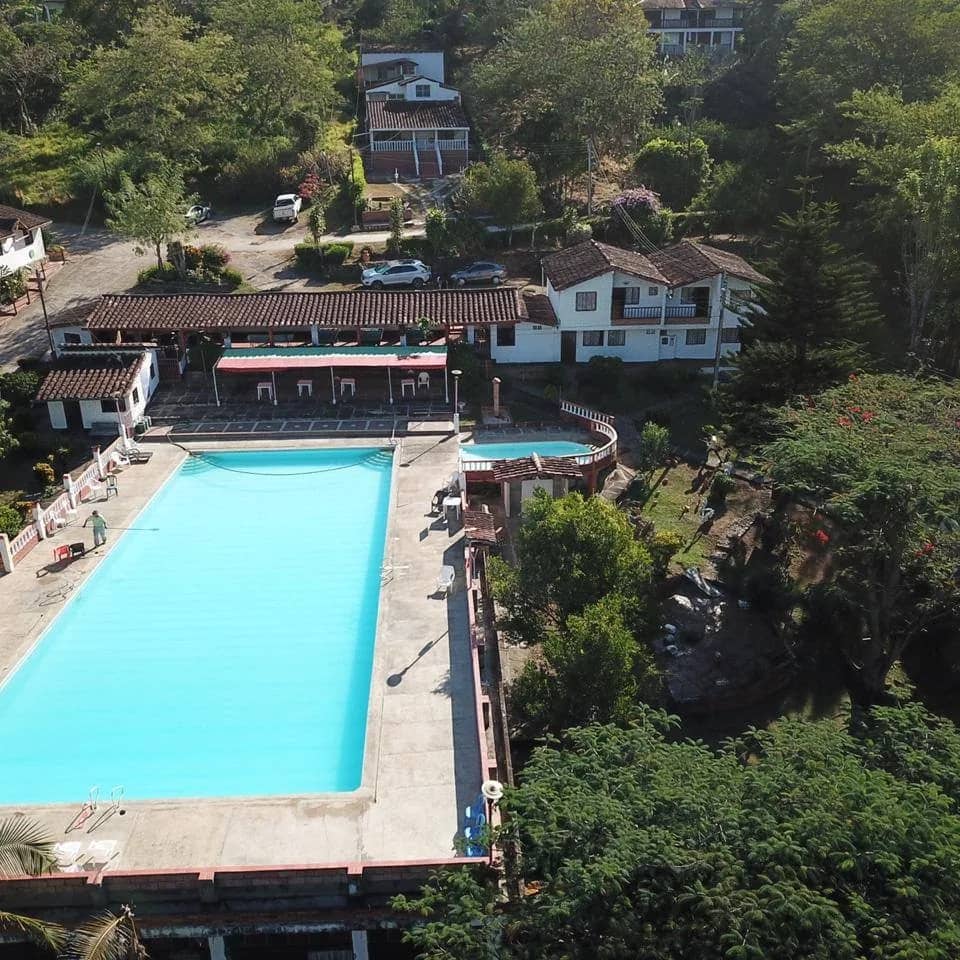 Aerial view of the pool and cabins at Hotel Dos Quebradas Afrodita among the trees