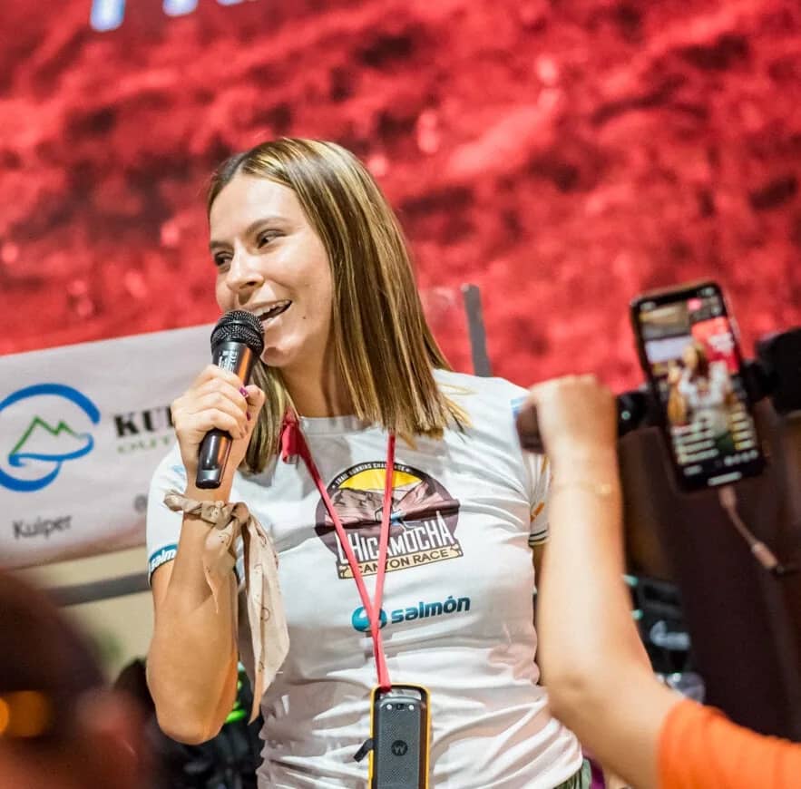 Natalia Boada Castellanos speaking into a microphone during the event