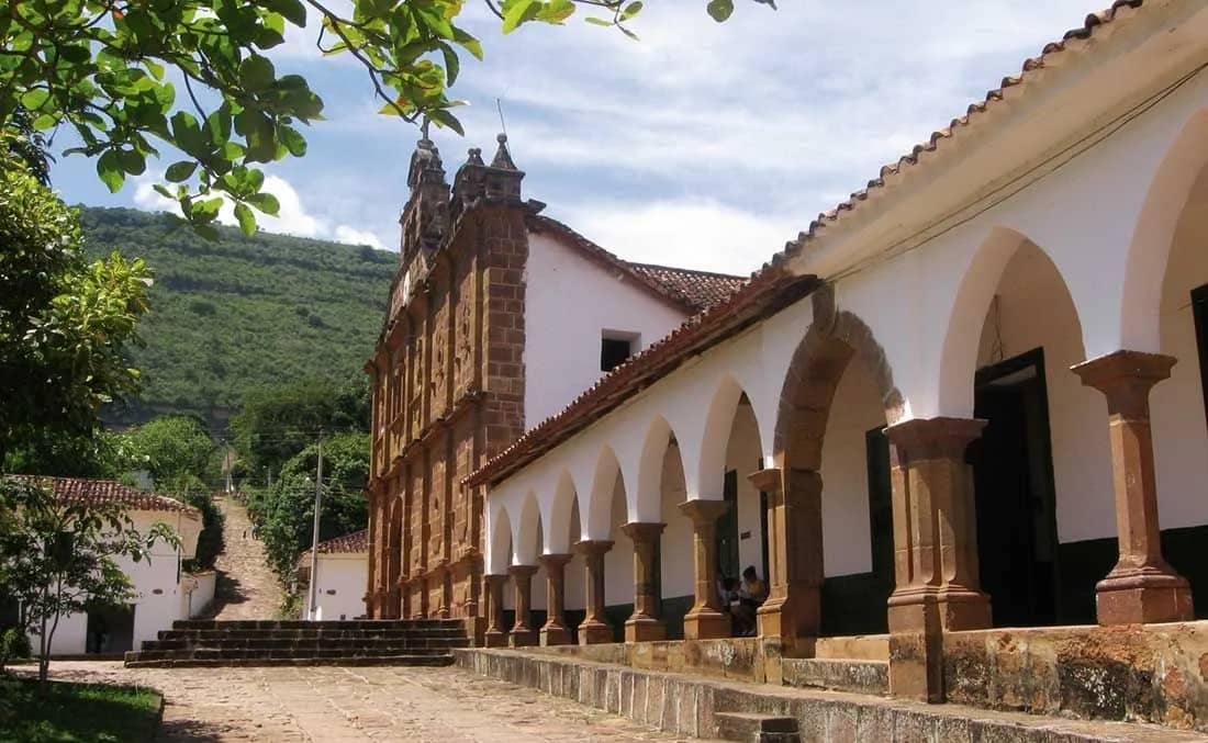 Templo parroquial de Cabrera y una casa colonial con arcos sobre una calle de tierra