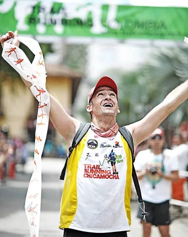 Runner celebrating with open arms as he crosses the first-edition finish line