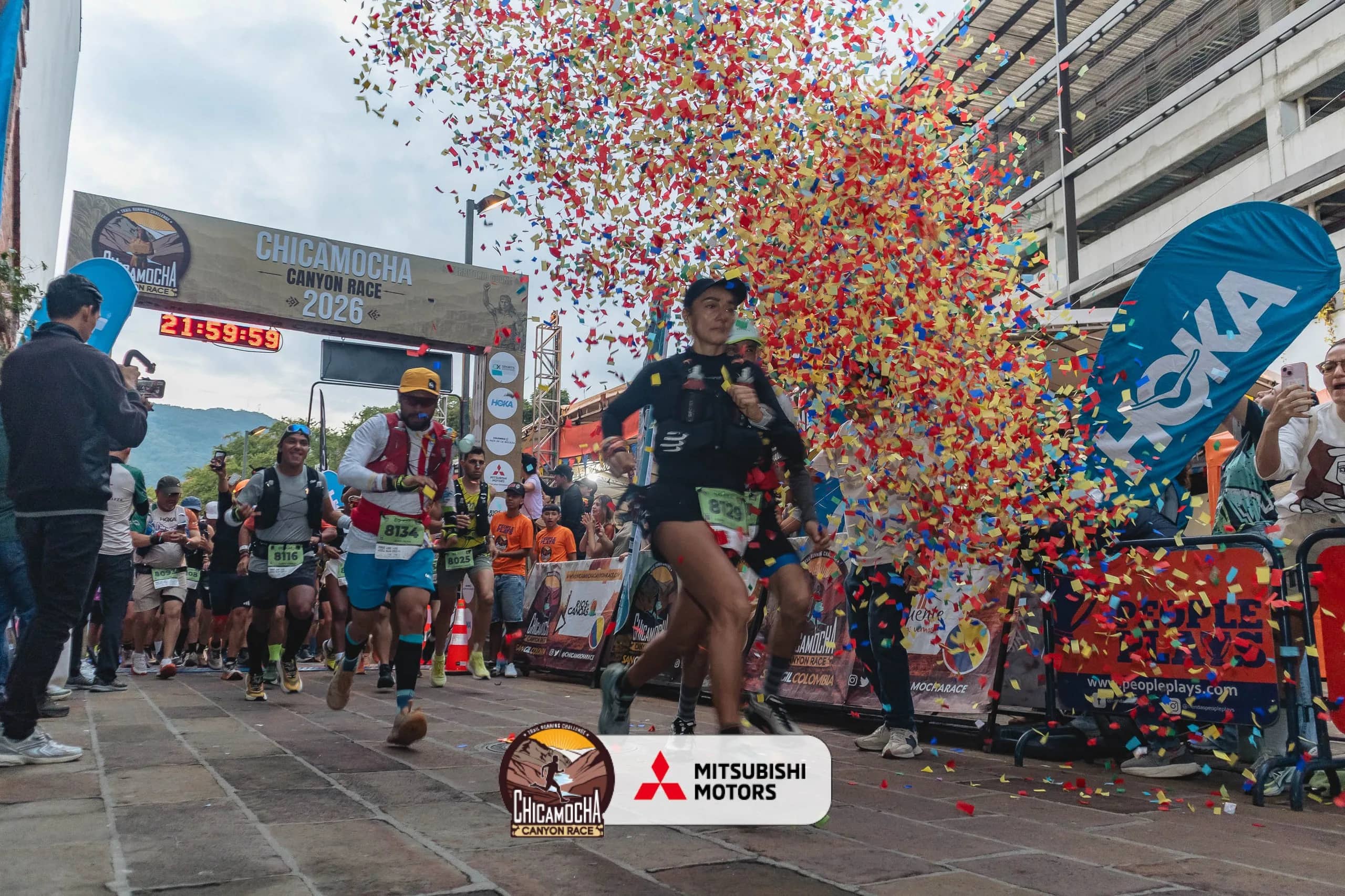 Runner crosses the 2026 finish line amid confetti, with the official clock behind