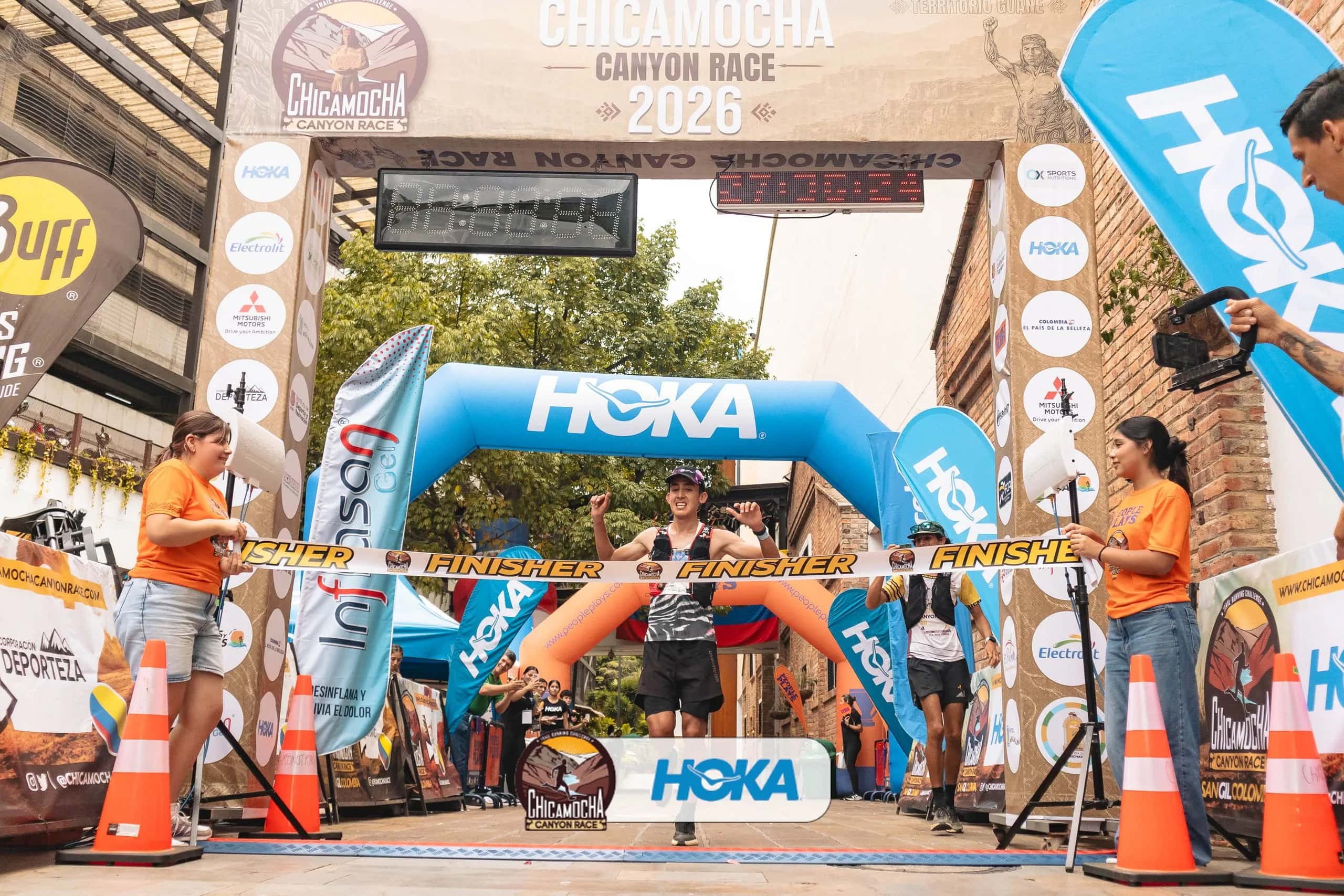 Runner breaks the finish tape under the Chicamocha Canyon Race 2026 gantry